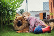Child lovingly embraces his pet dog. Chow Chow. Outdoor portrait